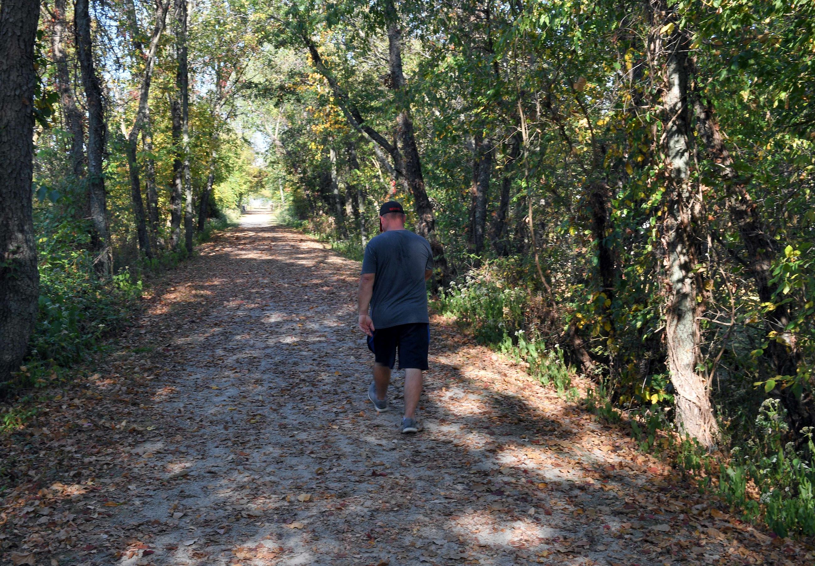 A man walking down a forested trail